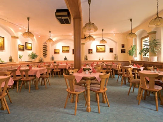 Gemütliches Restaurant mit Holzmöbeln, runden Tischen und rosa Tischdecken, umgeben von Pflanzen und Bildern an den Wänden.Cozy restaurant with wooden furniture, round tables and pink tablecloths, surrounded by plants and pictures on the walls.Útulná restaurace s dřevěným nábytkem, kulatými stoly a růžovými ubrusy, obklopená rostlinami a obrazy na stěnách.Przytulna restauracja z drewnianymi meblami, okrągłymi stołami i różowymi obrusami, otoczona roślinami i obrazami na ścianach.Gezellig restaurant met houten meubels, ronde tafels en roze tafelkleden, omringd door planten en foto's aan de muren.Ristorante accogliente con mobili in legno, tavoli rotondi e tovaglie rosa, circondato da piante e quadri alle pareti.