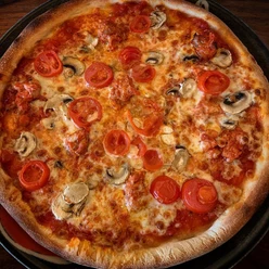 Pizza mit saftigen Tomatenscheiben, frischen Champignons und würziger Tomatensauce auf dünnem Teig.
