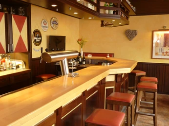 Hotel Zur Post_Kneipe Gemütliche Bar mit Holztresen, Barhockern und dekorierten Wänden in einem einladenden Ambiente.