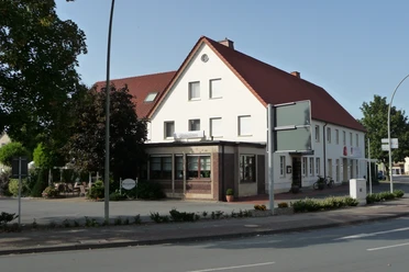 Hotel Zur Post_Außenansicht Zweistöckiges Gasthaus mit weißen Wänden, rotem Ziegeldach und umliegenden Bäumen an einer Straße.