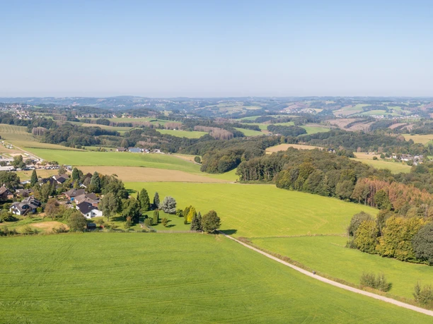 Panorama Heckberg Landschaftspanorama von Much: Weite Felder und Wälder unter einem klaren blauen Himmel.