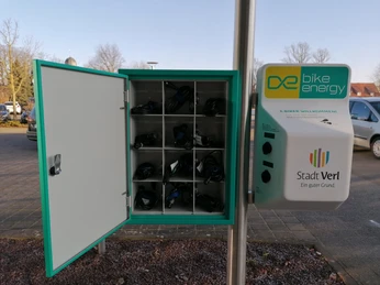 Fahrrad-Ladestation in Verl: Offenes Fach zeigt aufgeladene Kabel, ideal für E-Bikes geeignet.