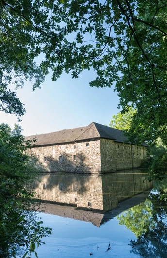 Wasserburg Haus Graven in Langenfeld Wasserburg Haus Graven in Langenfeld: Umgeben von Wassergraben, Bäumen und historischer Architektur.