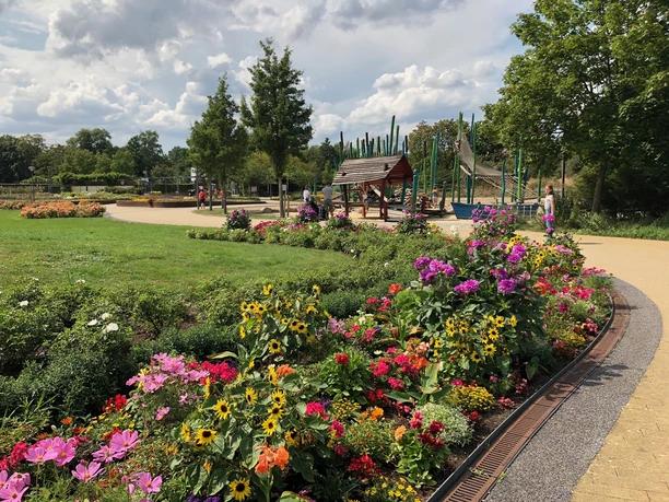 Blick auf Blütenpracht und Spielplatz im Gartenschaupark Rietberg