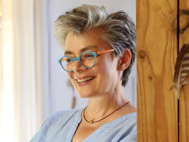 Porträt Taimi Zaeske Die lächelnde Schmuckdesignerin Taimi Zaeske mit ihrer markanten blauen Brille.