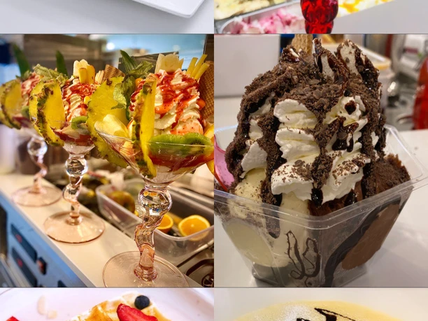 Verschiedene kunstvoll dekorierte Eisdesserts, Waffeln und Crêpes mit frischen Früchten und Soßen.