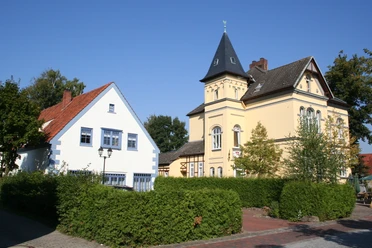 Altes Rathaus Historisches Rathausensemble mit gelbem Turmgebäude und benachbartem weißen Fachwerkhaus.