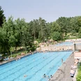 Freibad 1999 zwei Becken_GroßeBergstadtrunde_2.JPG Zwei große Schwimmbecken im Freibad von Bäumen und Liegewiese umgeben; Menschen entspannen.