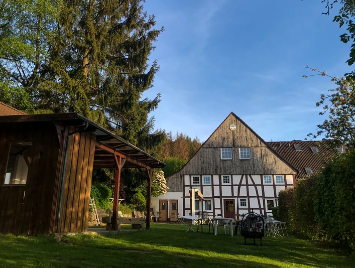 Naturfreundehaus Außenansicht Fachwerkhaus mit Garten und Bäumen, kombiniert traditionelle Architektur und grüner Außenbereich.