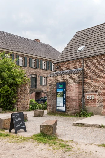 Haus Bürgel in Monheim am Rhein Ehemaliger römischer Gutshof mit historischem Klinkerbau und begrüntem Hof, umgeben von Natur.