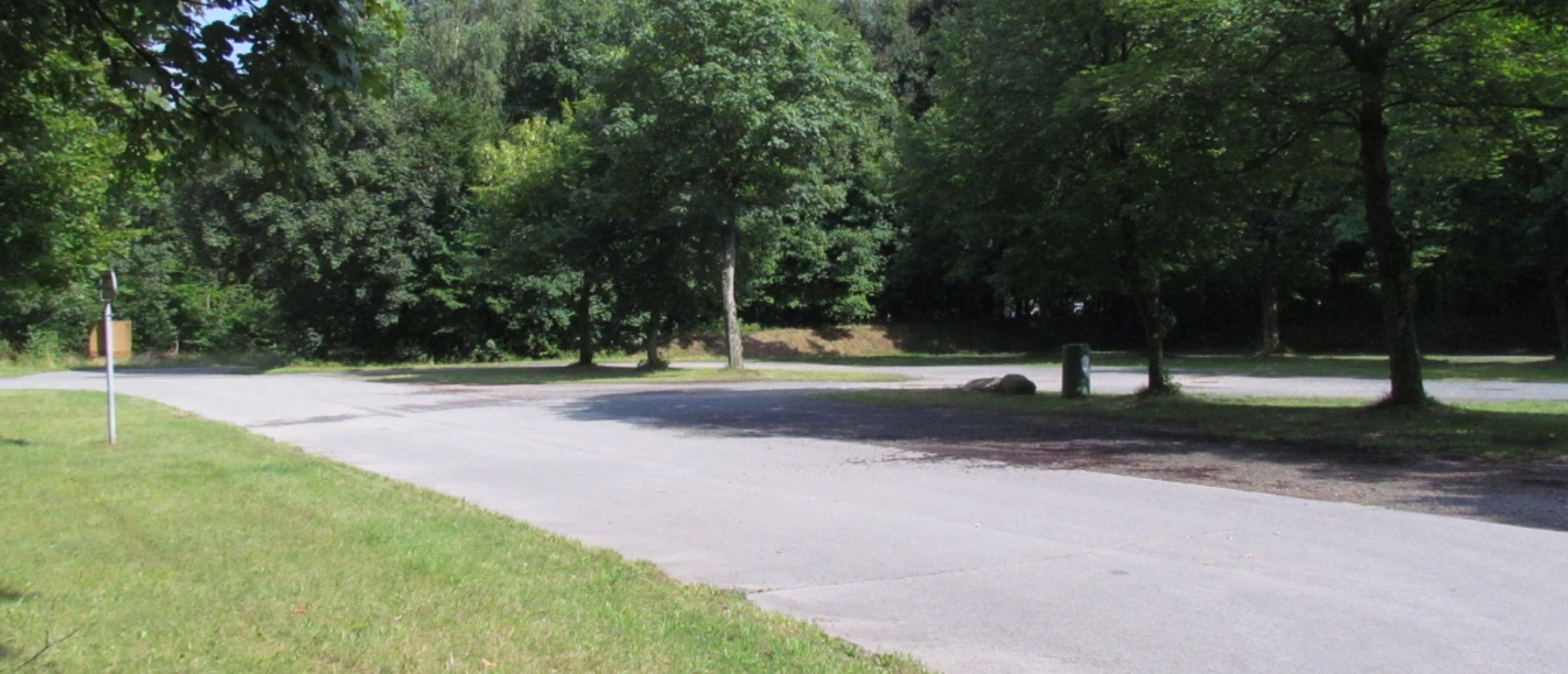 Stellplatz Kronsbergheide (3).JPG Asphaltierter Wohnmobilstellplatz, umrahmt von grünen Bäumen und Wiesen.