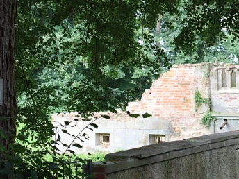 Ellerburg.JPG Verfallene Backsteinmauer einer alten Ruine, umgeben von üppigem Grün und Bäumen im Hintergrund.