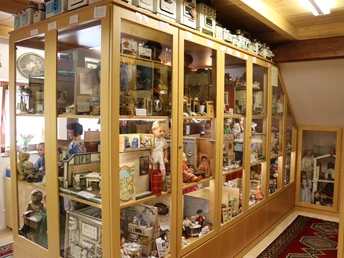 Spielzeugmuseum mit Vitrinen voller klassischer Puppen, Blechspielzeug und historischen Modellen.