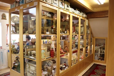 Spielzeugmuseum Spielzeugmuseum mit Vitrinen voller klassischer Puppen, Blechspielzeug und historischen Modellen.