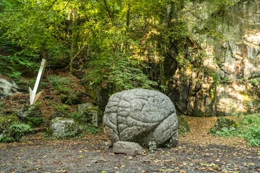 Kunstweg MenschenSpuren "Memoria Mundi" im Neandertal bei Erkrath Steinskulptur "Memoria Mundi" umgeben von Wald im Neandertal mit strukturierter Oberfläche.