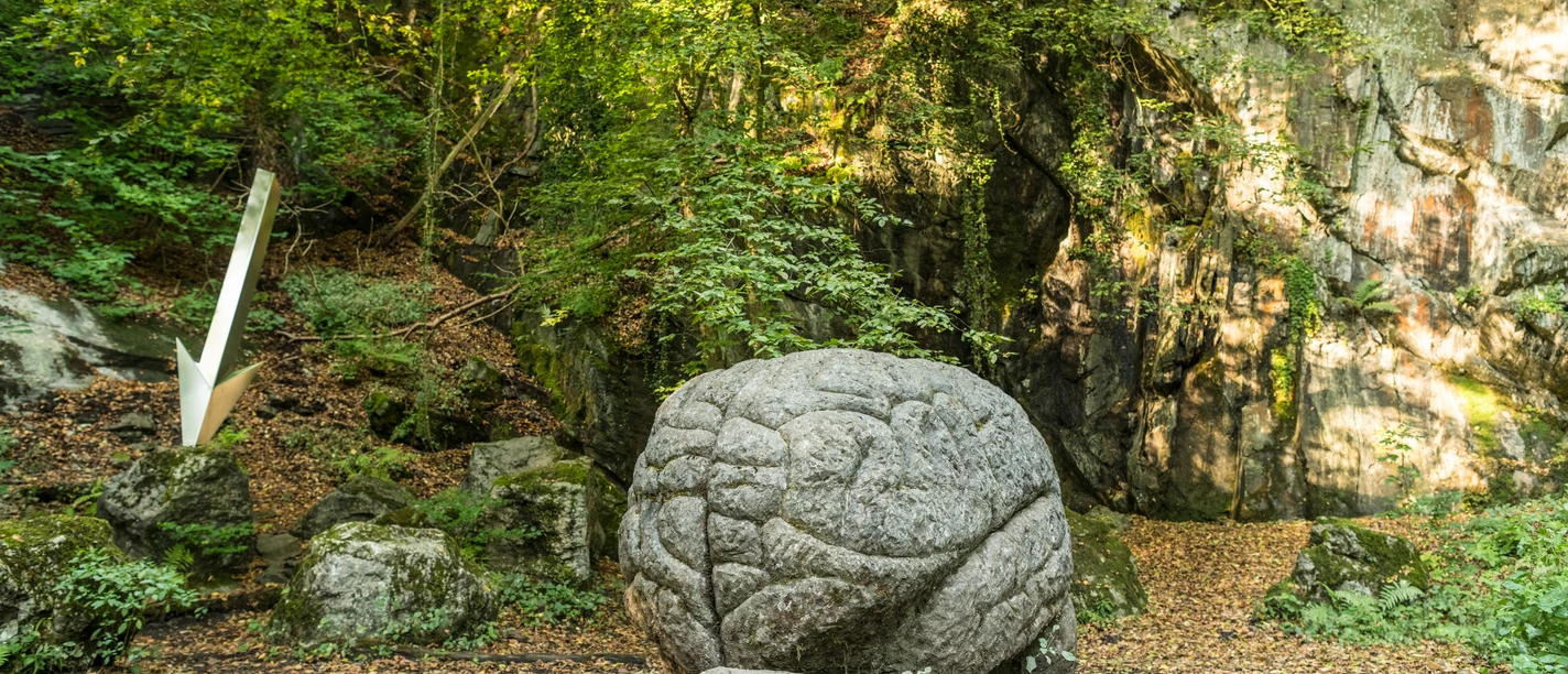 Kunstweg MenschenSpuren "Memoria Mundi" im Neandertal bei Erkrath Steinskulptur "Memoria Mundi" umgeben von Wald im Neandertal mit strukturierter Oberfläche.