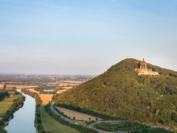 Das Kaiser-Wilhelm-Denkmal thront auf einem bewaldeten Hügel, umgeben von einer weitläufigen Landschaft.