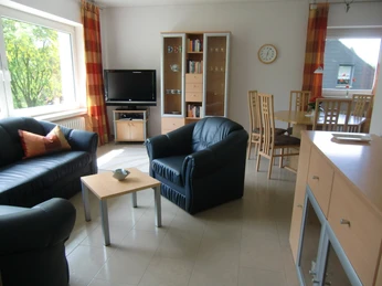 Wohnzimmer Wohnzimmer mit Ledersesseln, TV, Bücherregal und Essbereich, lichtdurchflutet und modern eingerichtet.