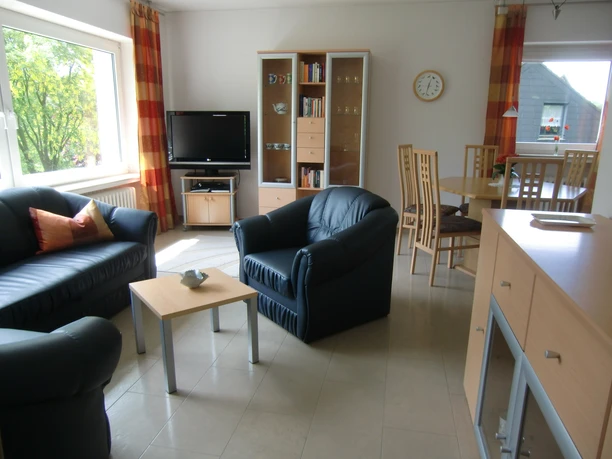 Wohnzimmer Wohnzimmer mit Ledersesseln, TV, Bücherregal und Essbereich, lichtdurchflutet und modern eingerichtet.