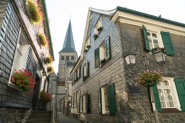 Oberstadt Mettmann mit Stadtgeschichtshaus und St. Lambertus Kirche Fachwerkhäuser mit Schieferfassaden und grünen Fensterläden in Mettmanns Oberstadt, St. Lambertus im Hintergrund.
