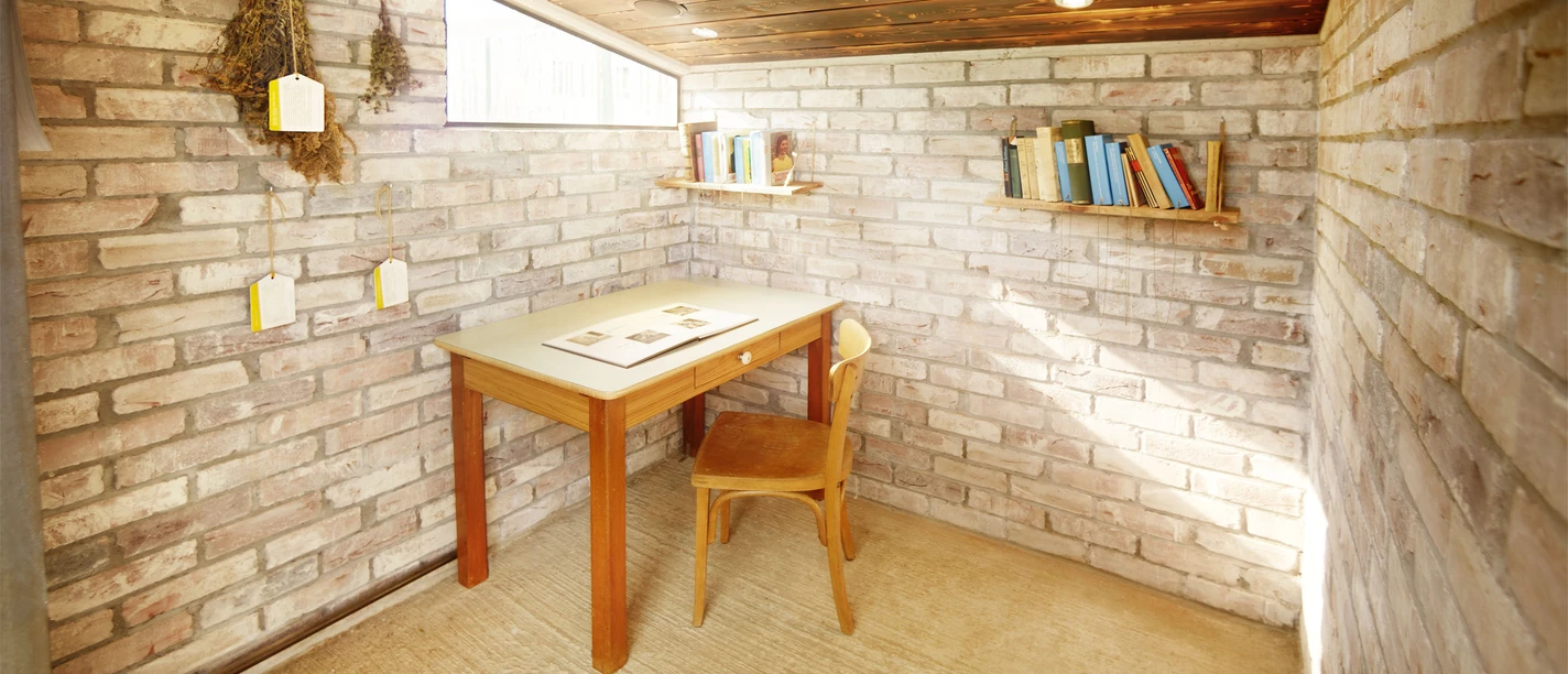 Hillas Leseschuppen in Monheim am Rhein Hillas Leseschuppen in Monheim am Rhein bietet eine einladende Leseecke mit Tisch, Stuhl und Regalen.