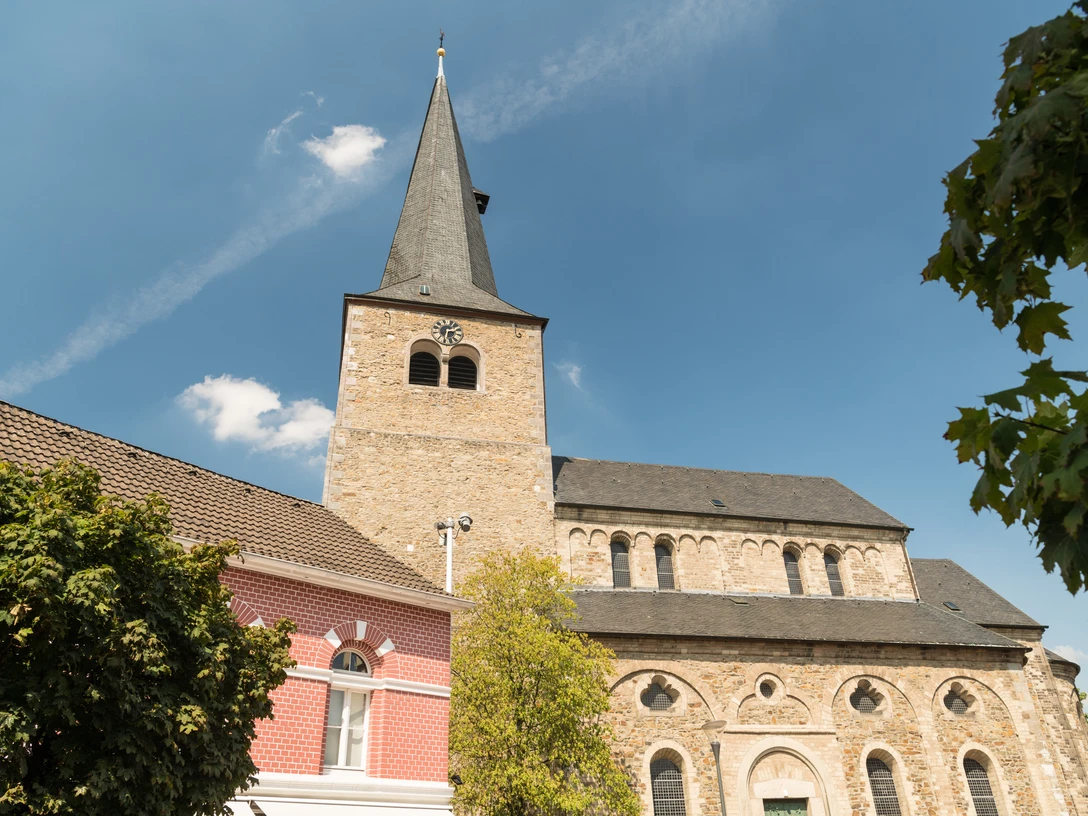 Reformationskirche zu Hilden Eine imposante Reformationskirche mit hoch aufragendem Turm und umliegenden historischen Gebäuden.