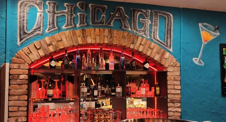 Vitrine in einer Bar, hier sind Gläser und Flaschen unter dem Schriftzug "Chicago" zu sehen
