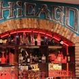Chicago Burger Bar Vitrine in einer Bar, hier sind Gläser und Flaschen unter dem Schriftzug "Chicago" zu sehen