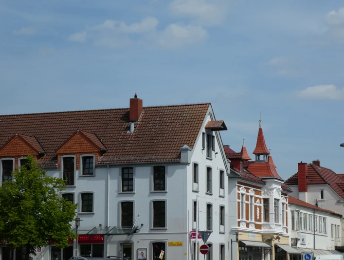 Speicher Scherf Historisches Backsteinhaus mit markantem Satteldach vor blauem Himmel in urbaner Umgebung.