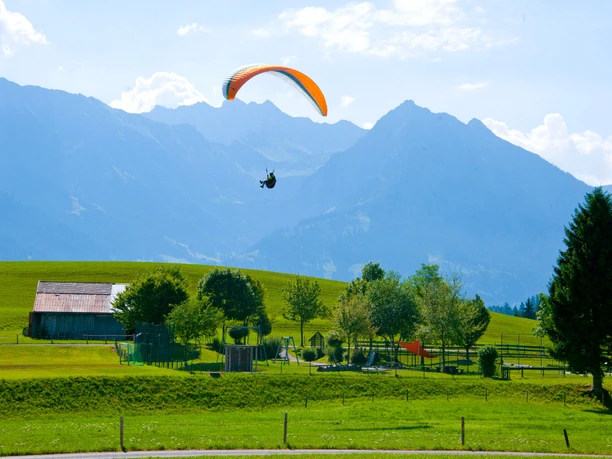Gleitschirmflieger kurz vor der Landung beim Restaurant Kitzebichl in Bolsterlang