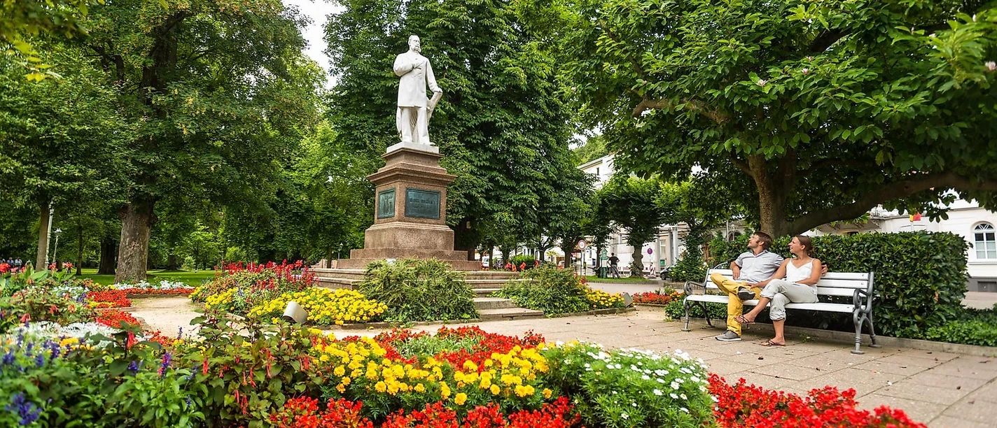 Denkmal umgeben von Blütenpracht