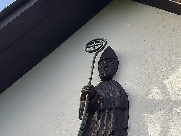 Holzfigur des Nikolaus im Giebel