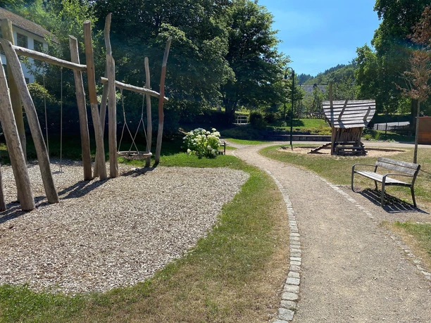 Schaukel mit Spielhäuschen auf Sandfläche