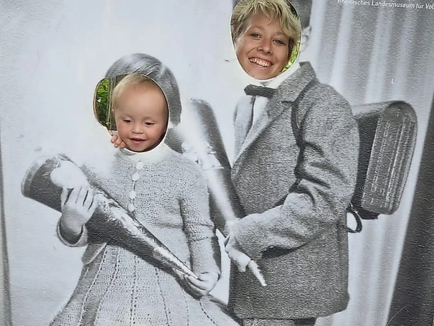 Kind und Mama hinter Fotowand