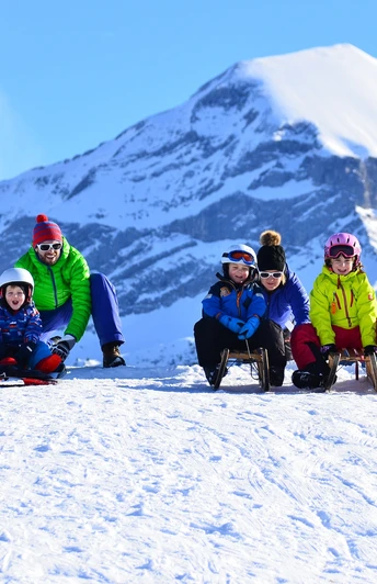 Familie auf Schlittelweg