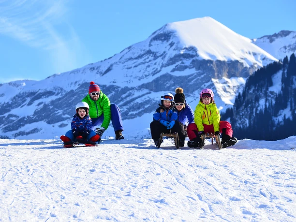 Familie auf Schlittelweg