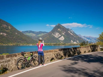 Eine Bikerin mit Rennrad macht ein Foto richtung Interlaken mit dem Harder