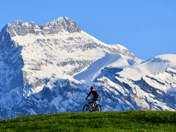 Biker unterwegs vor verschnietem Berg in der Region Aeschi