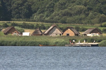 Blick vom Noor zur Landbrücke und zu den rekonstruierten Häusern © Stiftung Schleswig-Holsteinische Landesmuseen