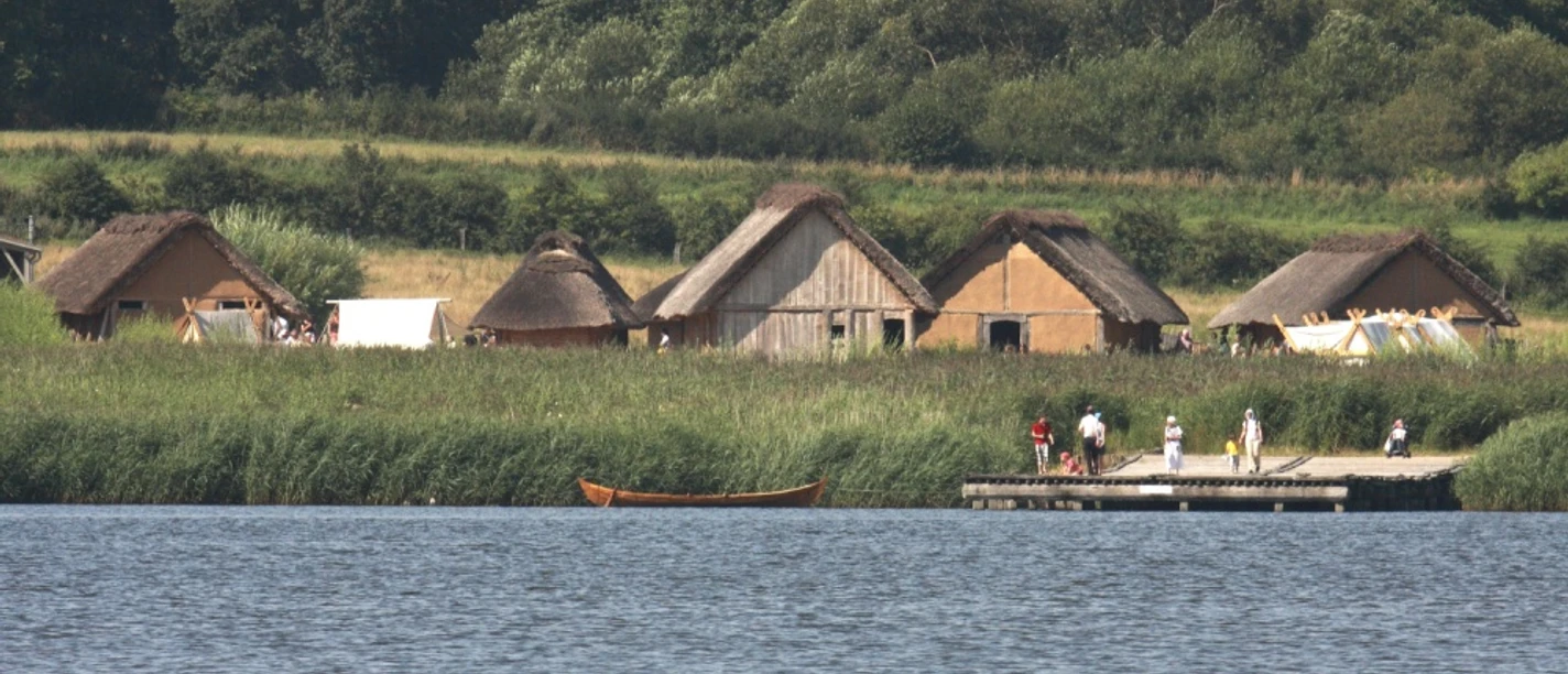 Blick vom Noor zur Landbrücke und zu den rekonstruierten Häusern © Stiftung Schleswig-Holsteinische Landesmuseen