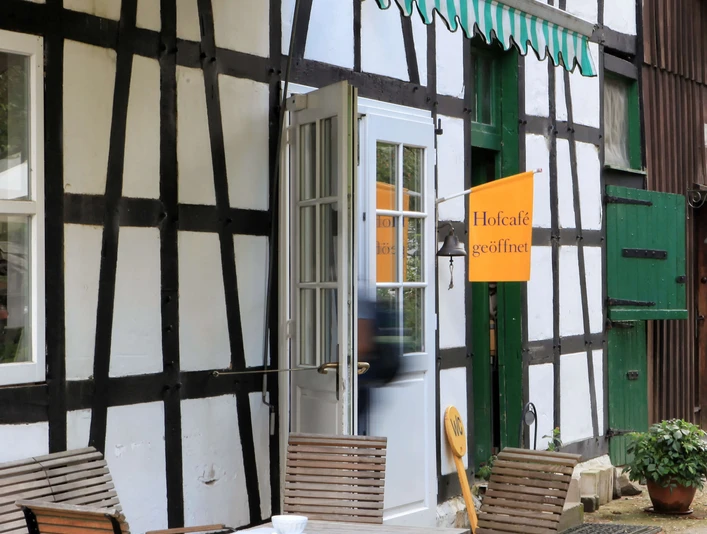 Biohof Hofcafe sull'Hof zur Hellen nella valle Windrath vicino a Velbert Tradizionale casa a graticcio con terrazza esterna e bar agricolo aperto nella valle Windrather vicino a Velbert.