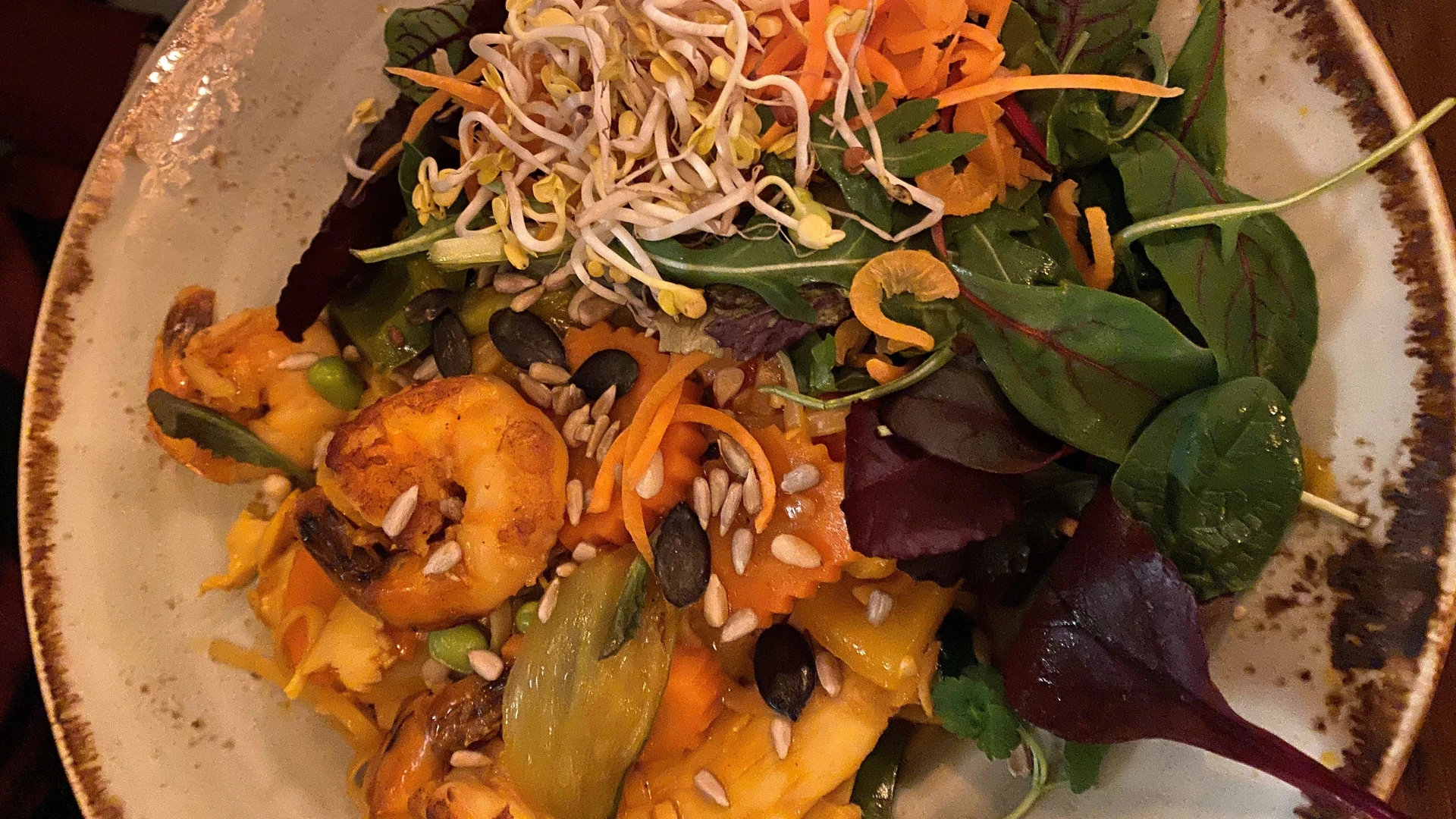 Exotic chicken pan served with prawns, crunchy vegetables, seeds and fresh sprouts.