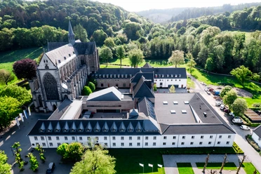 Youth Education Center Haus Altenberg Aerial view of Mariawald Abbey amidst green landscape, surrounded by forests and hills.