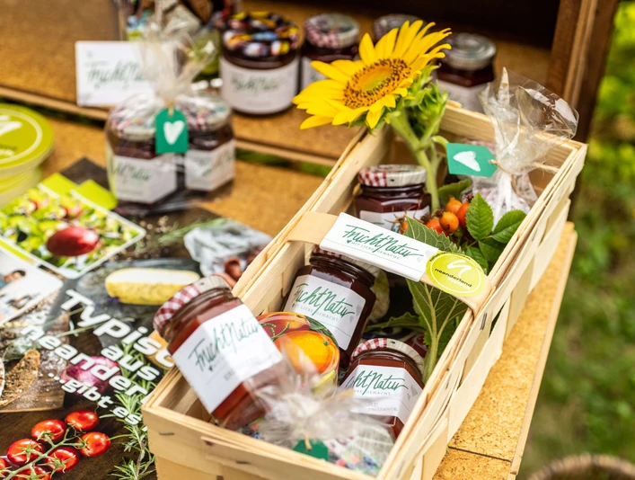 FruchtNatur spreads from Langenfeld A table with various fruit spreads from FruchtNatur and a sunflower in a basket.