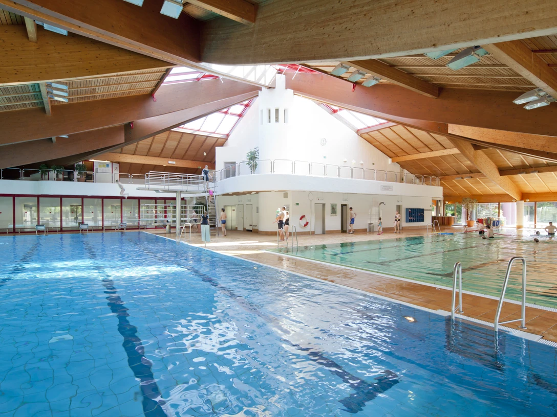 Hildorado swimming pool in Hilden A large swimming pool with different areas, natural light and wooden architecture.