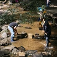 Construction of a dam on the Hilden adventure playground Children play by the stream and build a small dam with stones at an adventure playground.