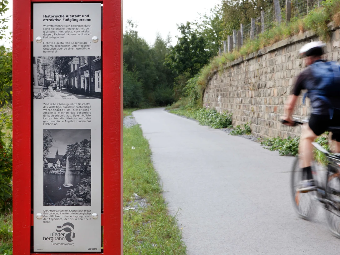 Tabellone informativo su Wülfrath sulla pista ciclabile panoramica Niederbergbahn Un pannello informativo sulla pista ciclabile panoramica Niederbergbahn con informazioni sul centro storico di Wülfrath.