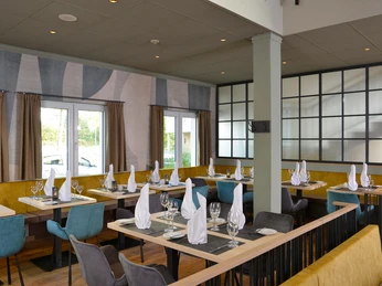 Restauracja w hotelu Sure by Best Western Hilden-Düsseldorf Jasna restauracja z nowoczesnymi meblami, stołami i dużymi oknami zapewniającymi mnóstwo naturalnego światła.