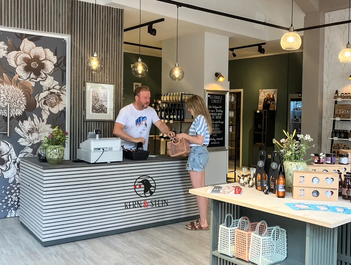 kern_und_stein_laden.jpg Boutique de la manufacture Kern & Stein à Gohlis, le propriétaire se tient derrière le comptoir de vente et sert un client