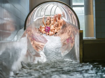 Zjeżdżalnia Erkratha Neanderbada Pięć osób zjeżdża z radością na szerokiej zjeżdżalni wodnej w Neanderbad w Erkrath.